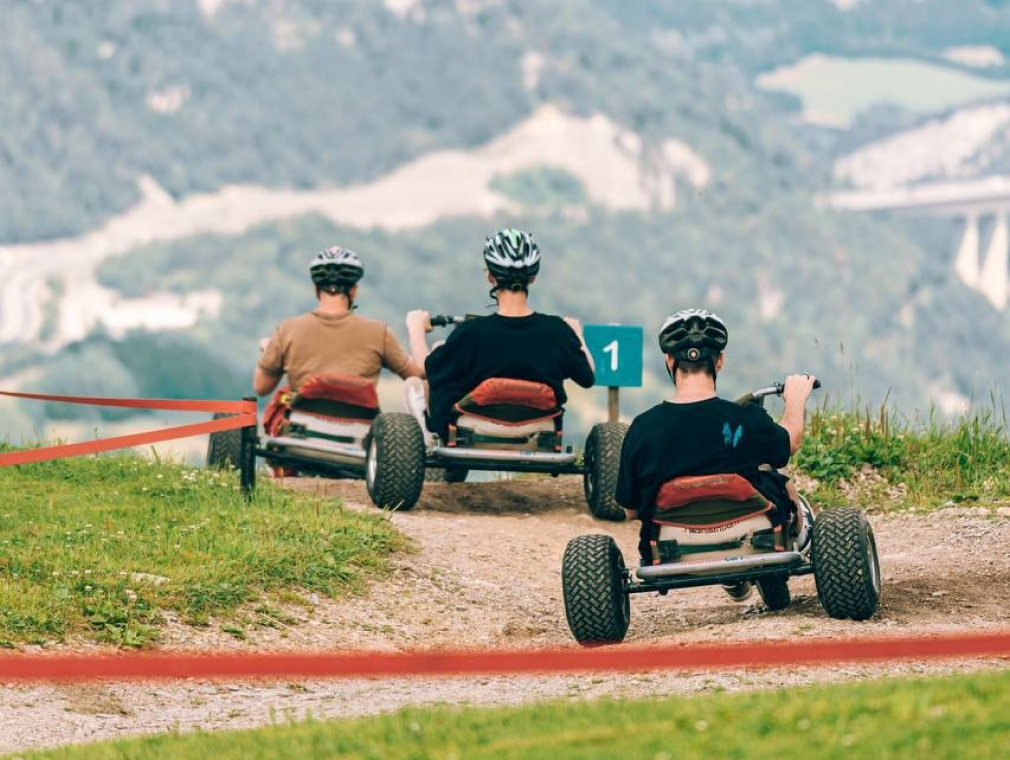 Sporthotel Mountaincarting a group of people riding go karts on a dirt road
